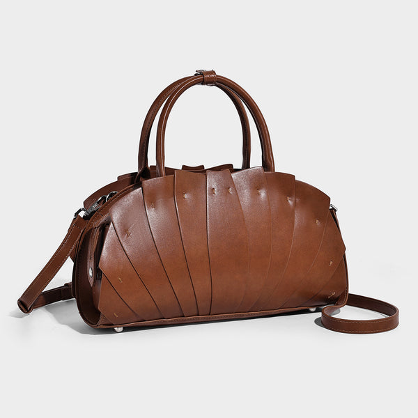 Structured dome satchel with fan-pleated leather-look exterior, dual top handles, and detachable shoulder strap, detail view
