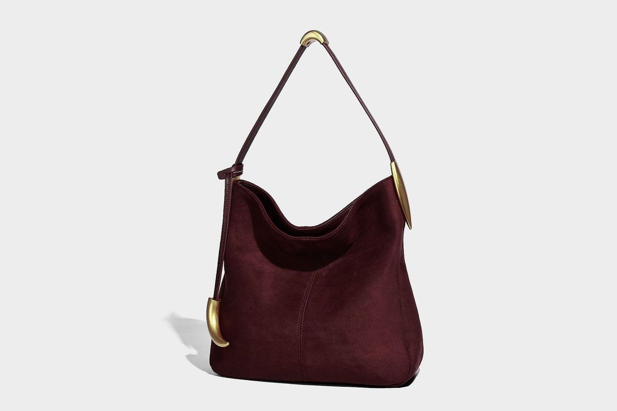 Beige-braune Hobo-Schultertasche mit lässiger Silhouette, matter Veloursleder-Optik, goldfarbenen halbmondförmigen Beschlägen und schmalem Schulterriemen, Detailaufnahme