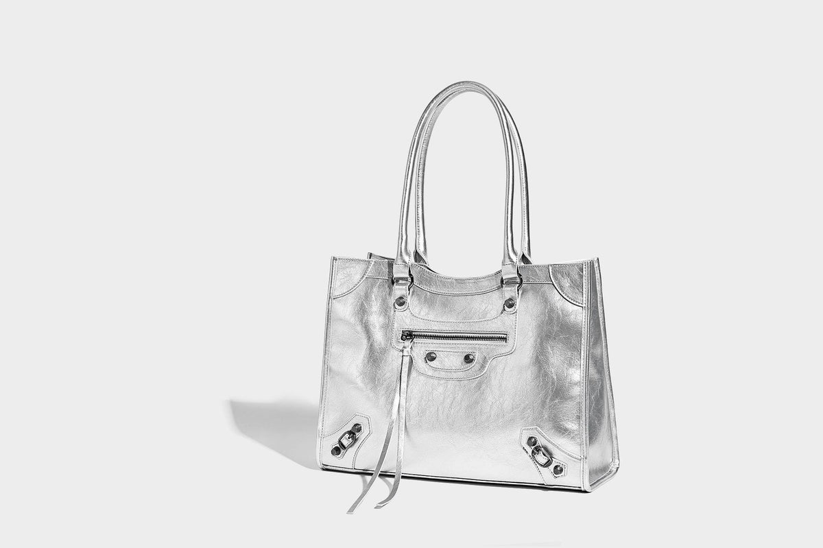 Large structured leather-look tote bag with front zip pocket, moto hardware accents, and long double shoulder straps, detail