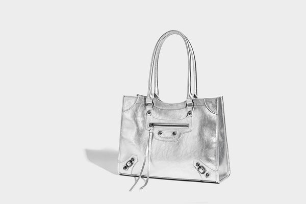 Large structured leather-look tote bag with front zip pocket, moto hardware accents, and long double shoulder straps, detail