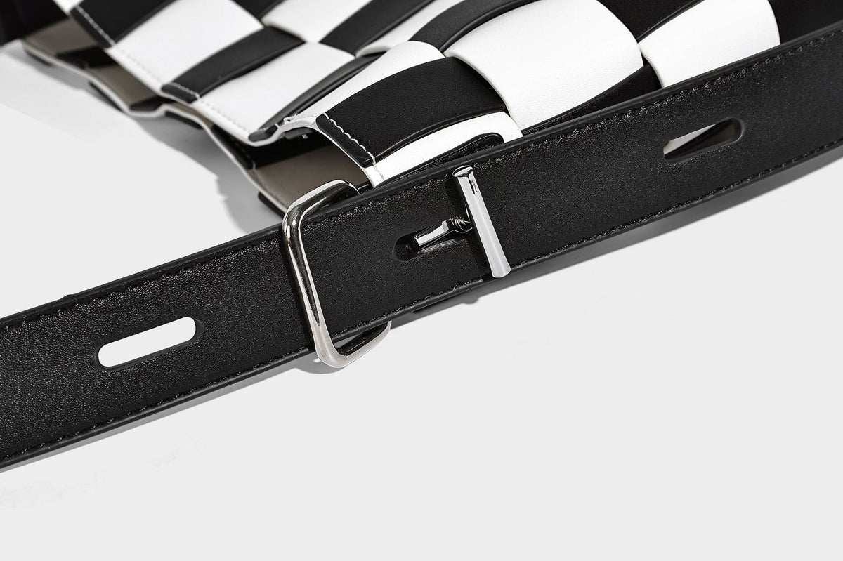 Hand-woven black-and-white checkerboard bucket bag with smooth black trim, silver-tone ring hardware, and adjustable