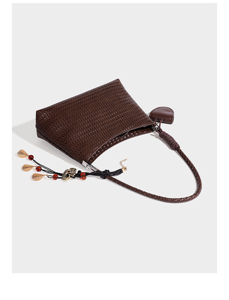 Woven-texture hobo shoulder bag in brown with braided top handle, adjustable crossbody strap, front flap pocket, and, detail