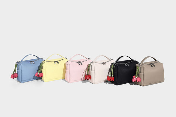 Kleine strukturierte Crossbody-Tasche mit Tragegriff aus genarbtem Material, Reißverschluss, silberfarbenen Beschlägen und optionalem Quastenanhänger