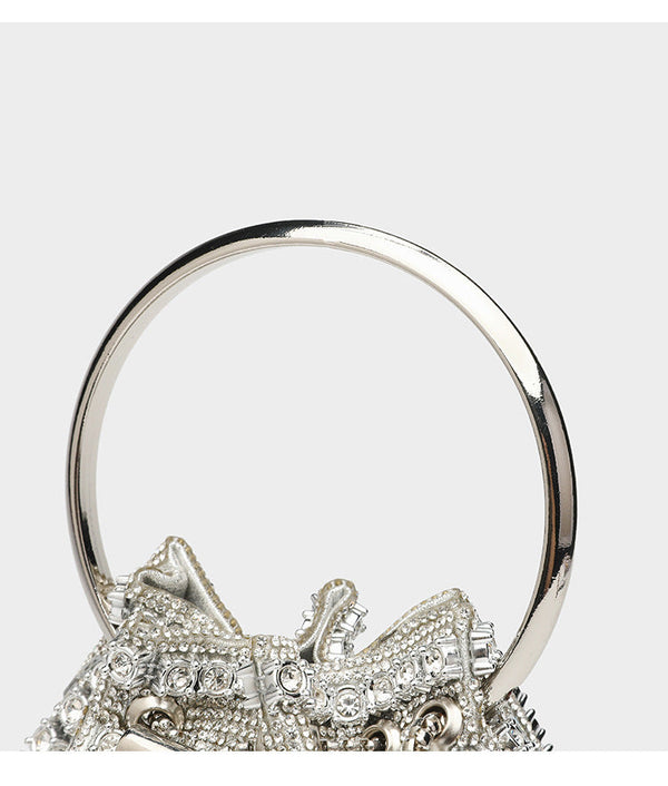 Mini crystal rhinestone bucket bag with circular ring top handle, drawstring closure, and silver chain shoulder strap, detail