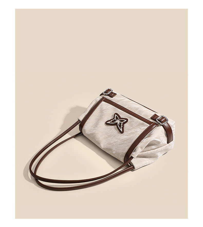 Structured crinkle-finish flap shoulder bag with butterfly metal appliqué and dark brown contrast trim, detail view 13