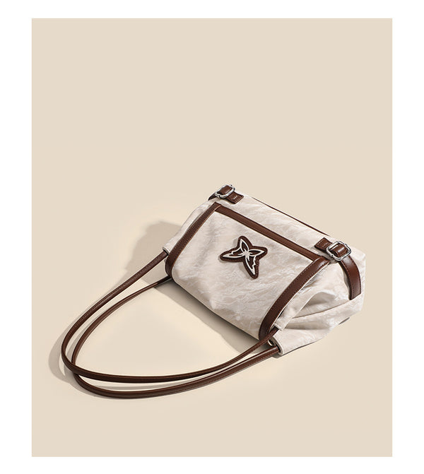 Structured crinkle-finish flap shoulder bag with butterfly metal appliqué and dark brown contrast trim, detail view 13