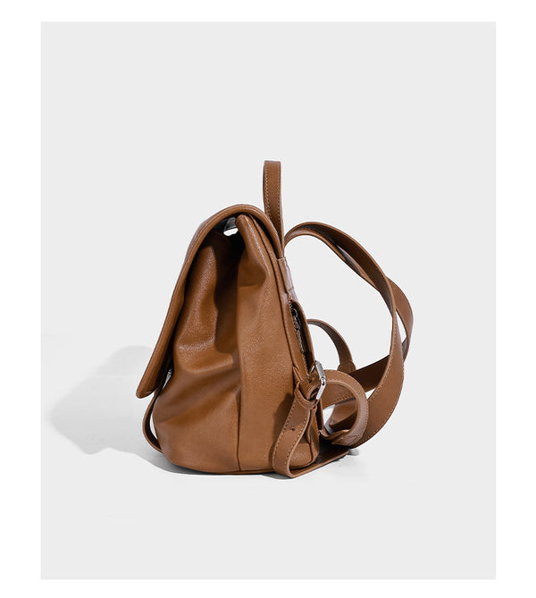 Structured tan leather-look flap backpack handbag with top handle, silver buckle hardware, and fold-over front closure