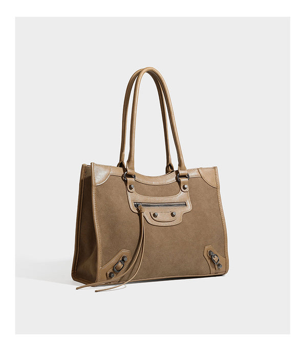Large structured tote bag with matte suede-like body, smooth leather-look trim, front zip pocket, stud hardware, and