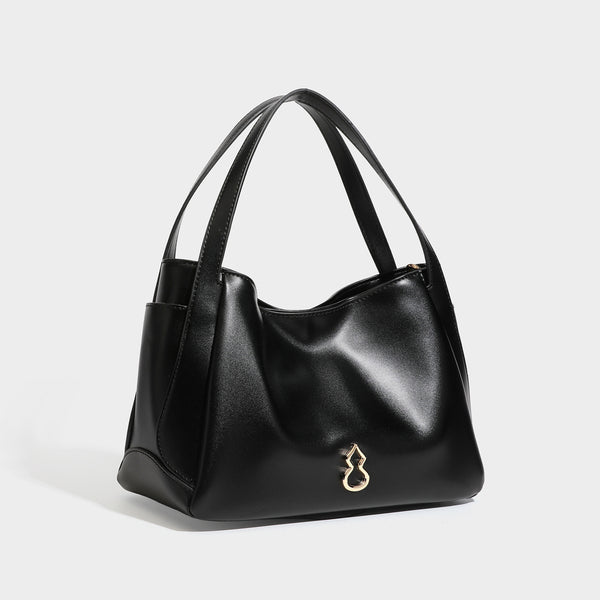 Structured glossy leather-look tote shoulder bag with dual top handles, detachable crossbody strap, side pockets, and, detail