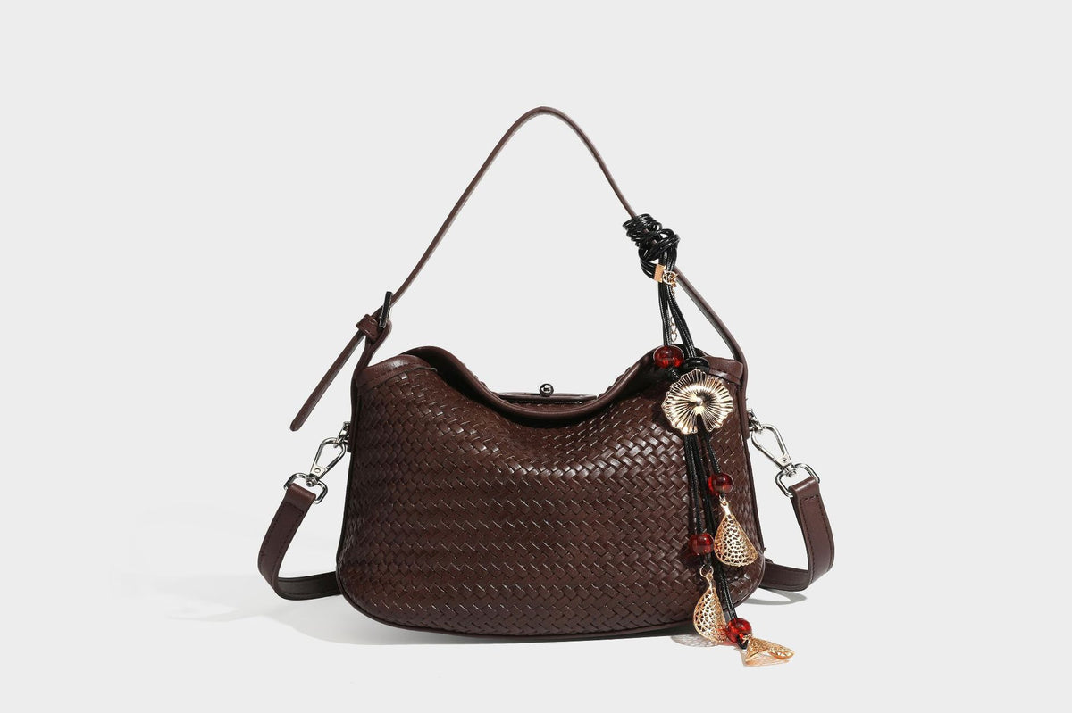 Small woven-look leather-look flap shoulder hobo bag in burgundy with silver-tone hardware and decorative tassel charm