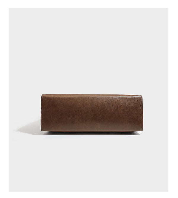 Structured suede-look convertible backpack handbag with flap closure and gold-tone emblem hardware in chocolate brown, detail