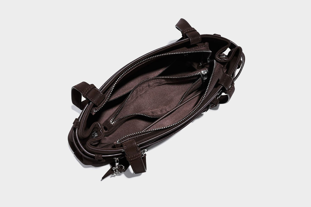 Structured trapezoid shoulder tote in dark brown matte suede-look finish with dual straps, wraparound belt bands