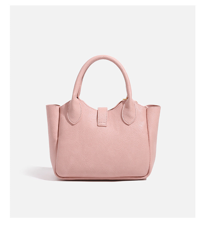 Small structured pebbled leather-look mini tote bag with gold-tone hardware, front toggle closure, knotted bear tassel charm