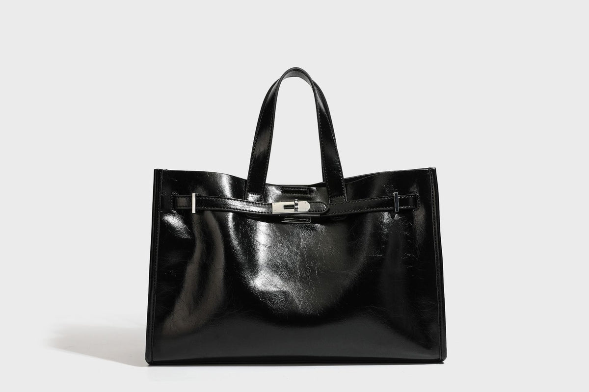 Strukturierte, glänzende Tote-Bag in Lederoptik mit silberfarbenem Drehverschluss, zwei Tragegriffen und abnehmbarem Schulterriemen, Detailansicht
