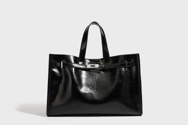 Strukturierte, glänzende Tote-Bag in Lederoptik mit silberfarbenem Drehverschluss, zwei Tragegriffen und abnehmbarem Schulterriemen, Detailansicht