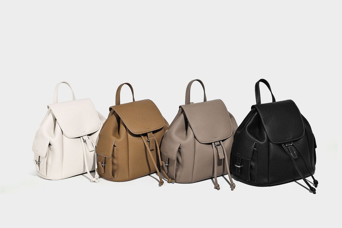 Compact pebbled leather-look flap drawstring backpack handbag with side pockets, top handle, and silver-tone hardware, detail