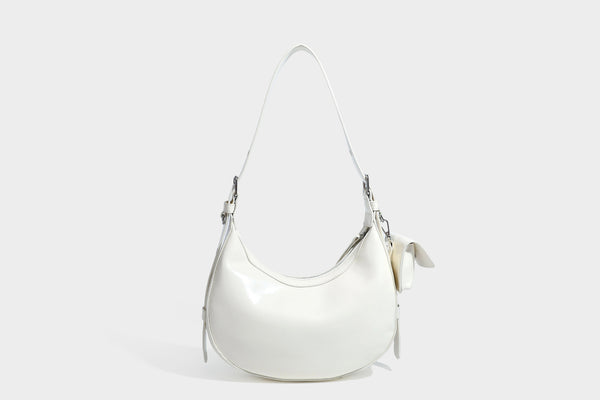 Glossy leather-look crescent hobo shoulder bag with dark contrast trim, silver-tone hardware, and attached mini flap pouch