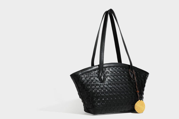 Large leather-look tote bag with geometric woven emboss, double shoulder straps, and round woven cord charm in brown, detail