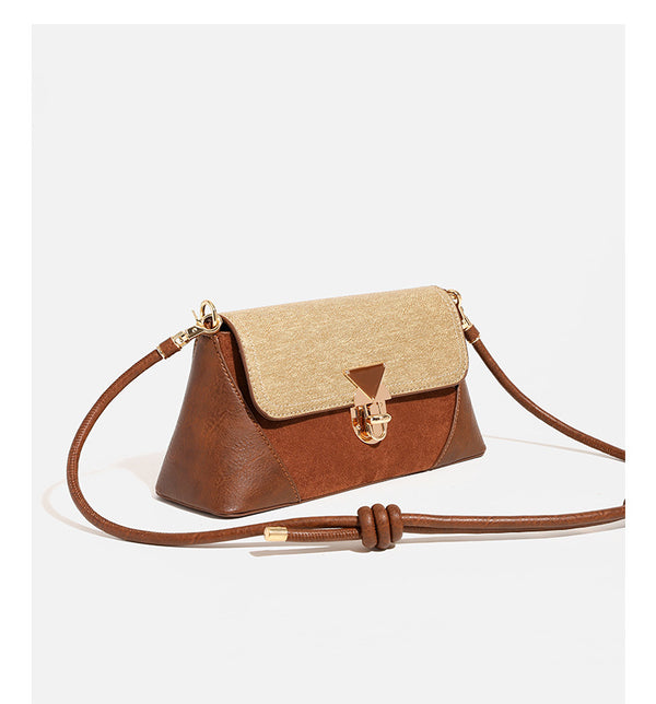 Structured trapezoid shoulder bag with pale textured flap, gold-tone triangular turn-lock closure, and long knotted cord