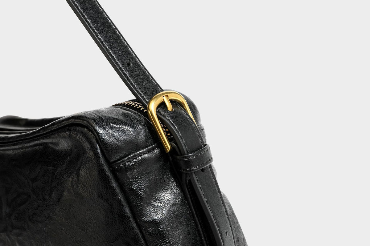 Compact black crinkled leather-look baguette shoulder bag with gold-tone arch hardware and adjustable strap, detail view 31