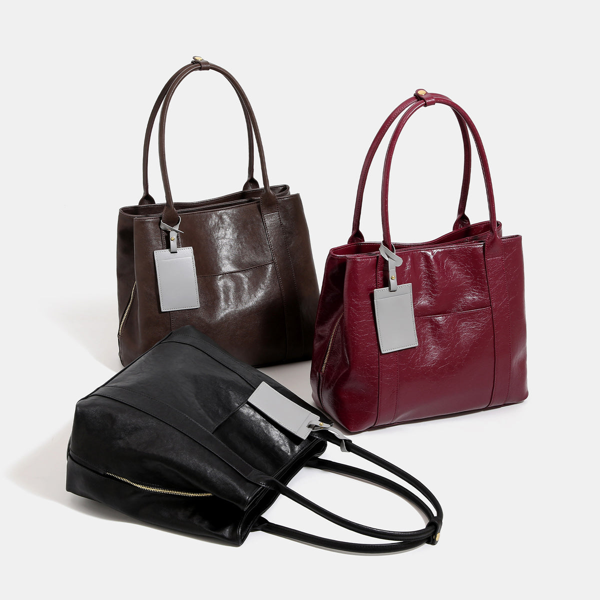 Large structured vintage leather-look tote bag with double shoulder straps, top zip closure, and gold-tone hardware, detail