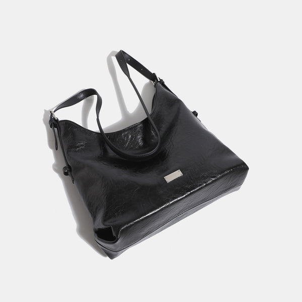 Slouchy hobo shoulder bag with glossy wrinkled leather-look finish, adjustable strap, and snap closure, detail view 4