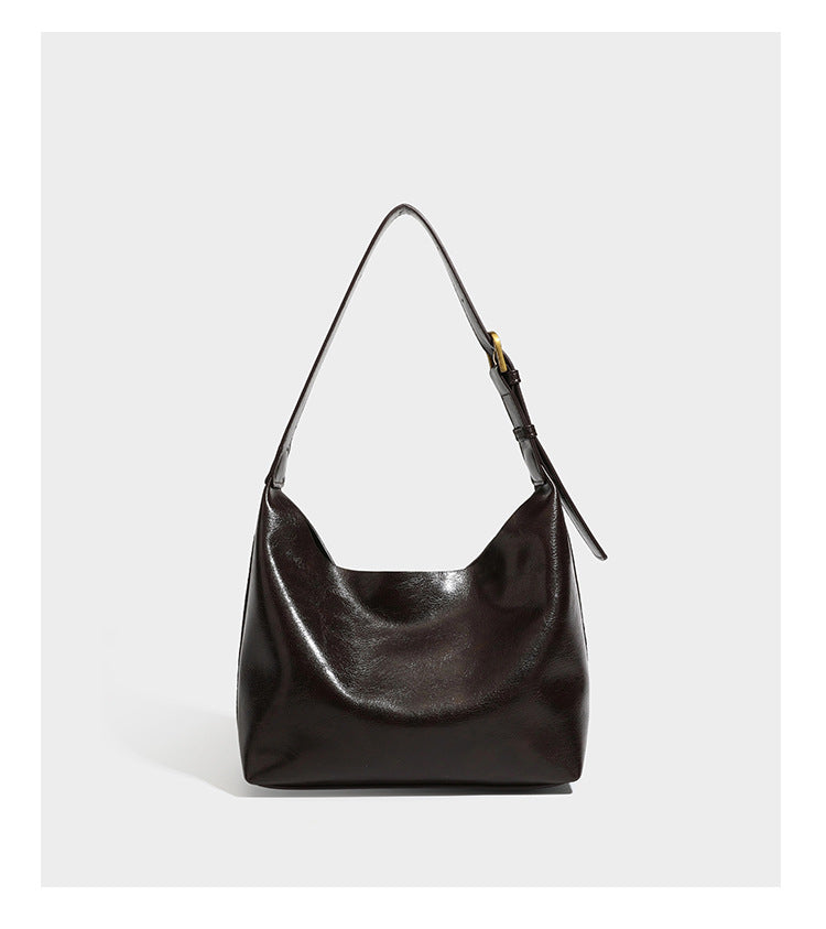 Dunkelbraune, lässig fallende Hobo-Schultertasche mit velourslederähnlich strukturierter Oberfläche, glatter lederähnlicher Paspelierung und Details in Antikgoldoptik, Detailansicht