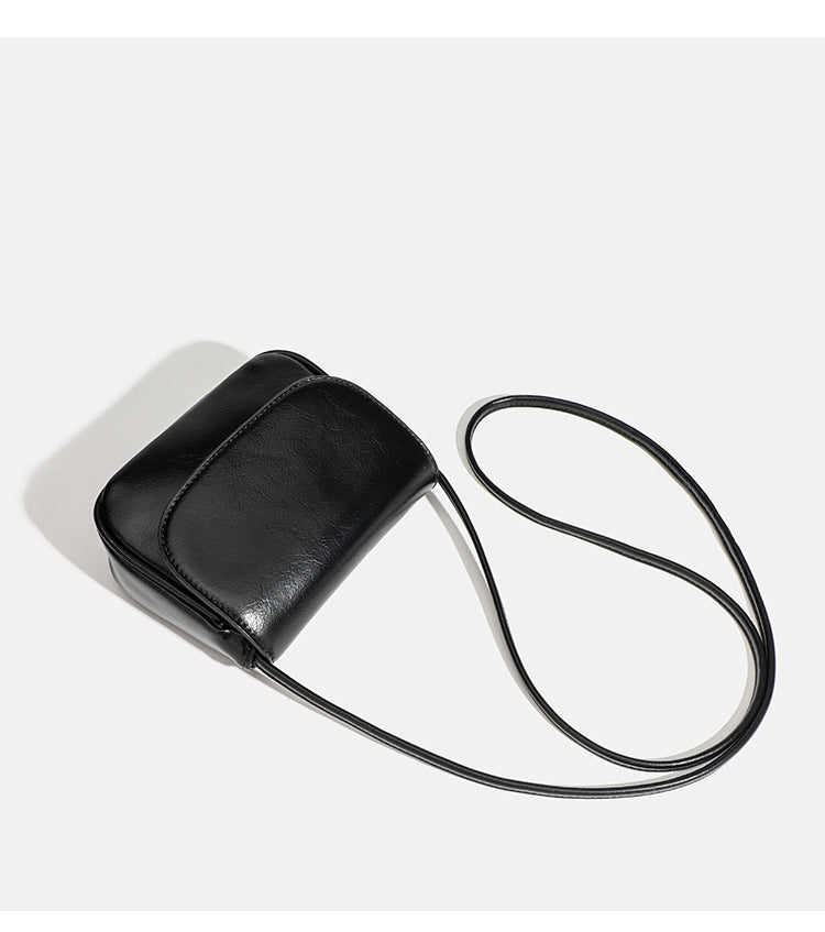 Compact rounded rectangular flap crossbody bag with glossy leather-look finish and long shoulder strap, detail view 20