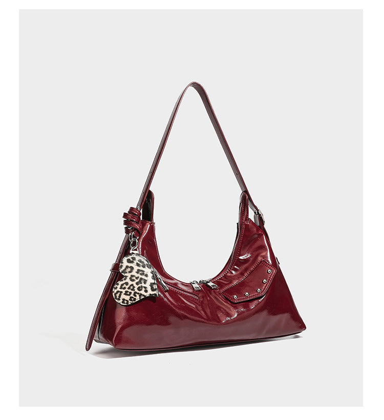 Glossy dark brown hobo shoulder bag with slim strap, front zip pocket, stud detail, and detachable leopard-print heart charm