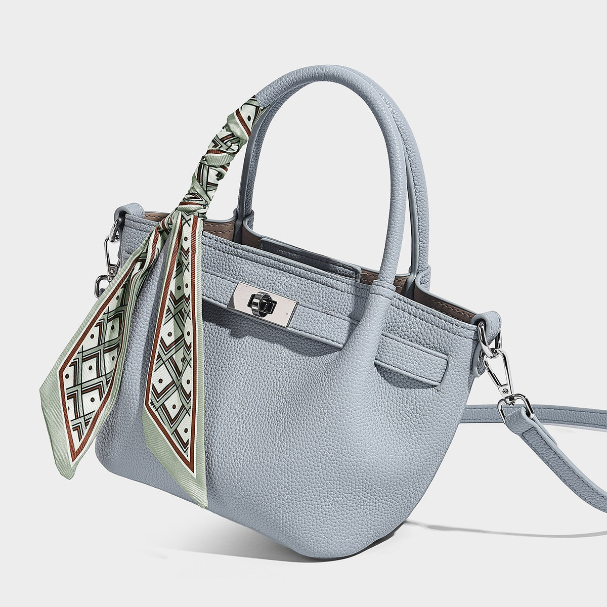 Small structured pebbled tote satchel in taupe with dual top handles, printed scarf tie, front turn-lock closure, and, detail