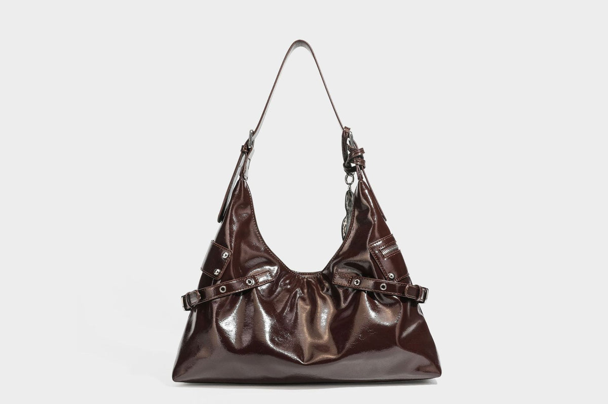 Glänzende dunkelbraune, lässig geschnittene Hobo-Schultertasche mit Riemendetail mit silberfarbenen Ösen, Reißverschlussfach auf der Vorderseite und Herz mit Leopardenmuster
