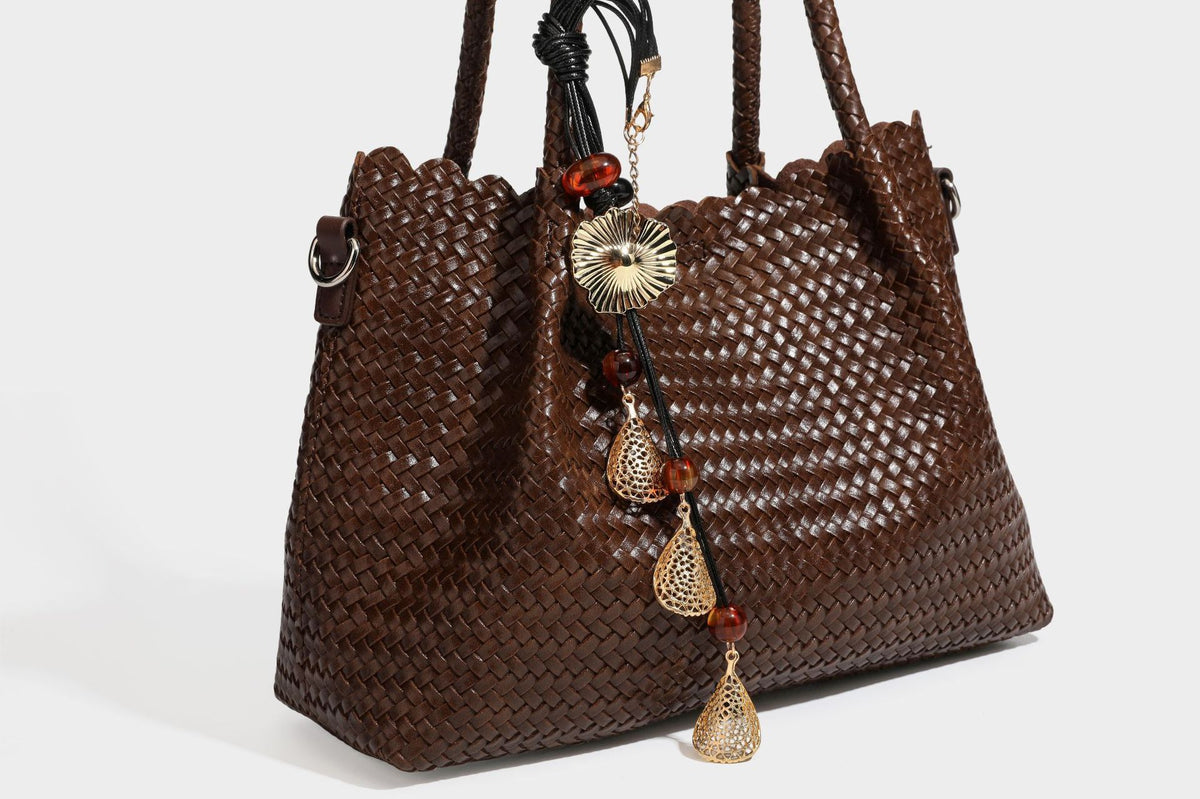 Strukturierte, glänzend gewebte Tote-Bag mit geschwungenem oberen Rand, geflochtenen Henkeln, abnehmbarem Crossbody-Riemen und Perlenquaste