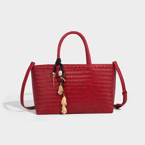 Structured woven-texture tote bag with brown braided top handles, decorative tassel charm, and detachable shoulder strap