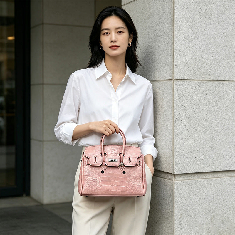 Croc-embossed structured trapezoid satchel with silver turn-lock hardware, rounded top handles, and detachable shoulder
