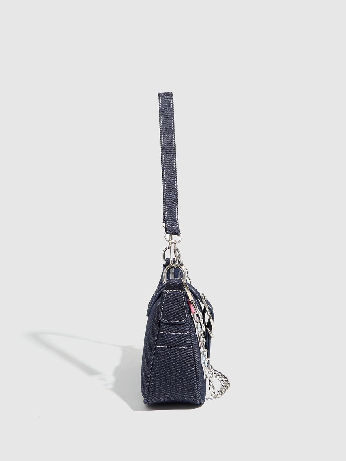 Dark navy denim-look shoulder bag with light blue and pink star appliqués, silver-tone buckle, chain strap, and short top