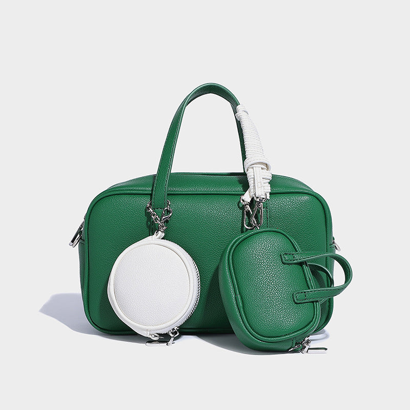 Structured pebbled leather-look Boston bowling bag in tan with blue detachable round mini pouch, dual top handles, and