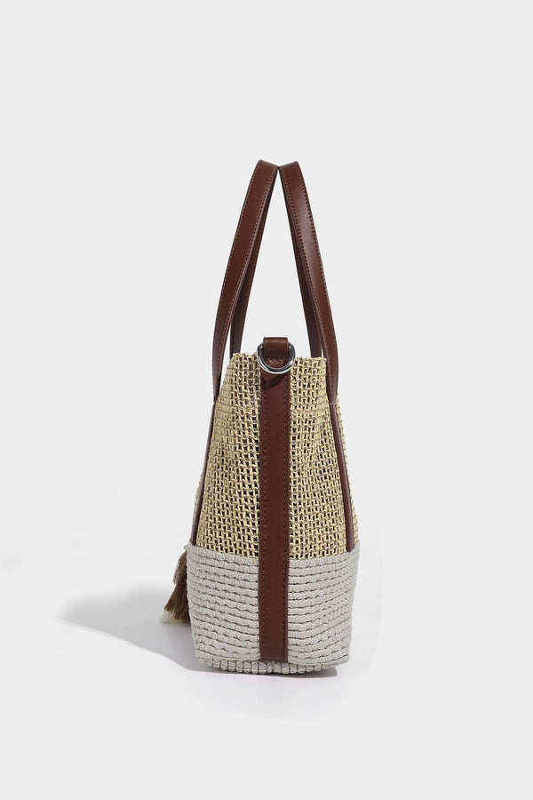 Two-tone open-weave tote bag in beige and cream with brown leather-look handles, tassel bead charm, and detachable