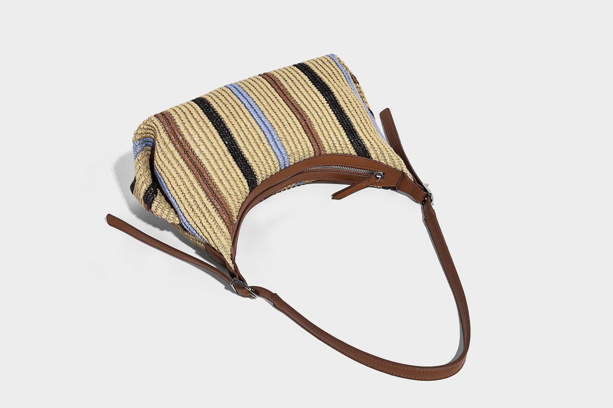 Slouchy woven straw hobo shoulder bag with beige, black, brown, and blue vertical stripes and brown leather-look trim, detail