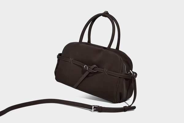 Strukturierte, matt genarbte Henkeltasche mit umlaufendem Riemen mit Ringbeschlägen, zwei Tragegriffen und abnehmbarem Crossbody-Riemen