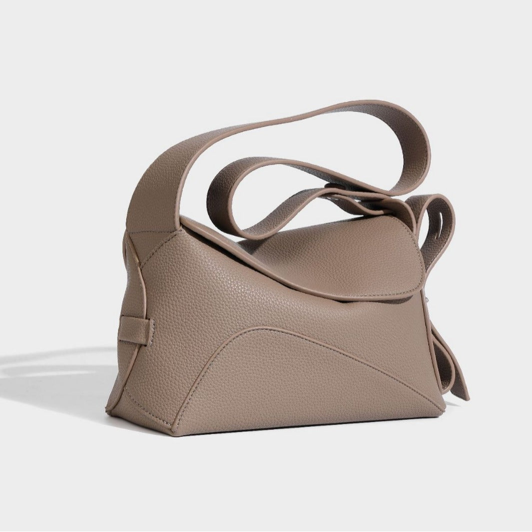 Structured curved-flap pebbled PU shoulder bag with sculptural loop strap detail, front view