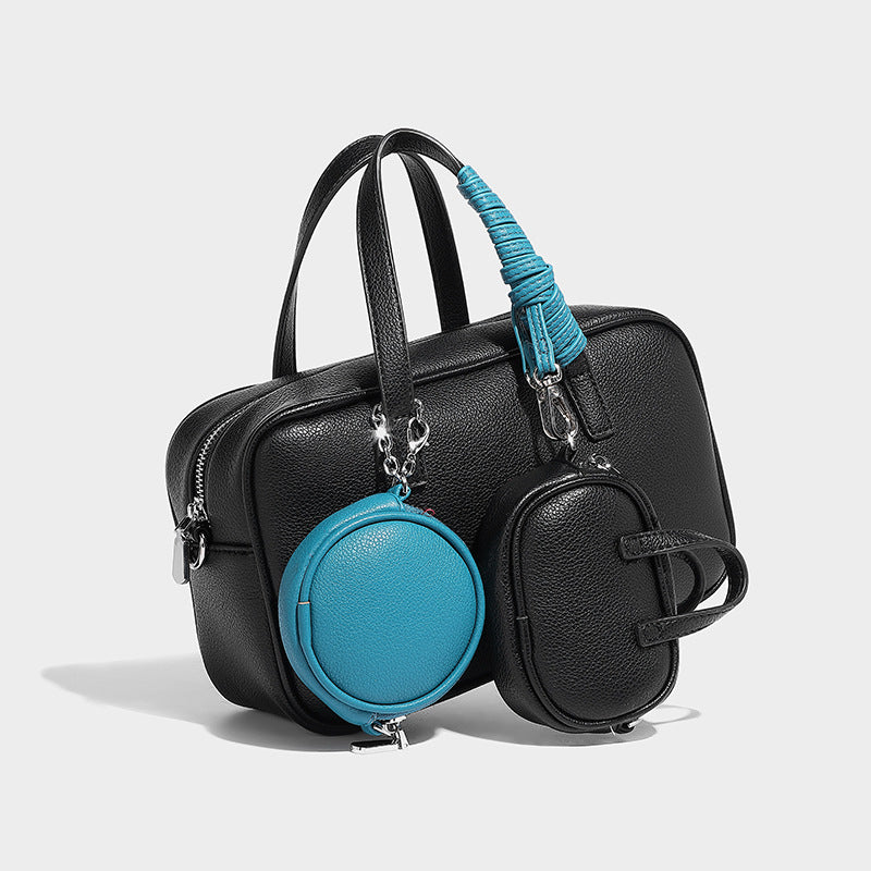 Structured pebbled leather-look Boston bowling bag in tan with blue detachable round mini pouch, dual top handles, and, front