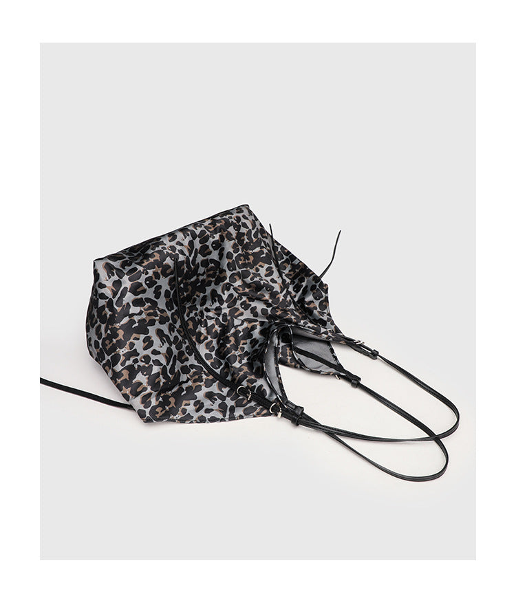 Large leopard-print slouchy tote shoulder bag in grey, black, and tan with gold-tone hardware and adjustable leather-look