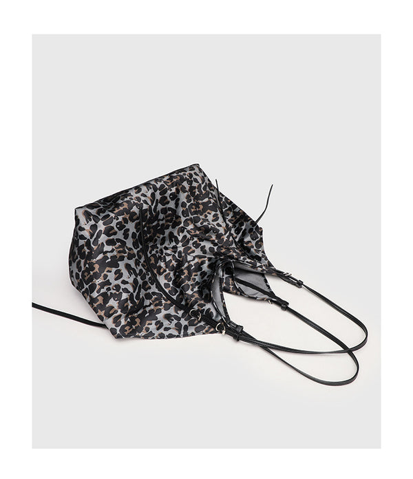 Large leopard-print slouchy tote shoulder bag in grey, black, and tan with gold-tone hardware and adjustable leather-look