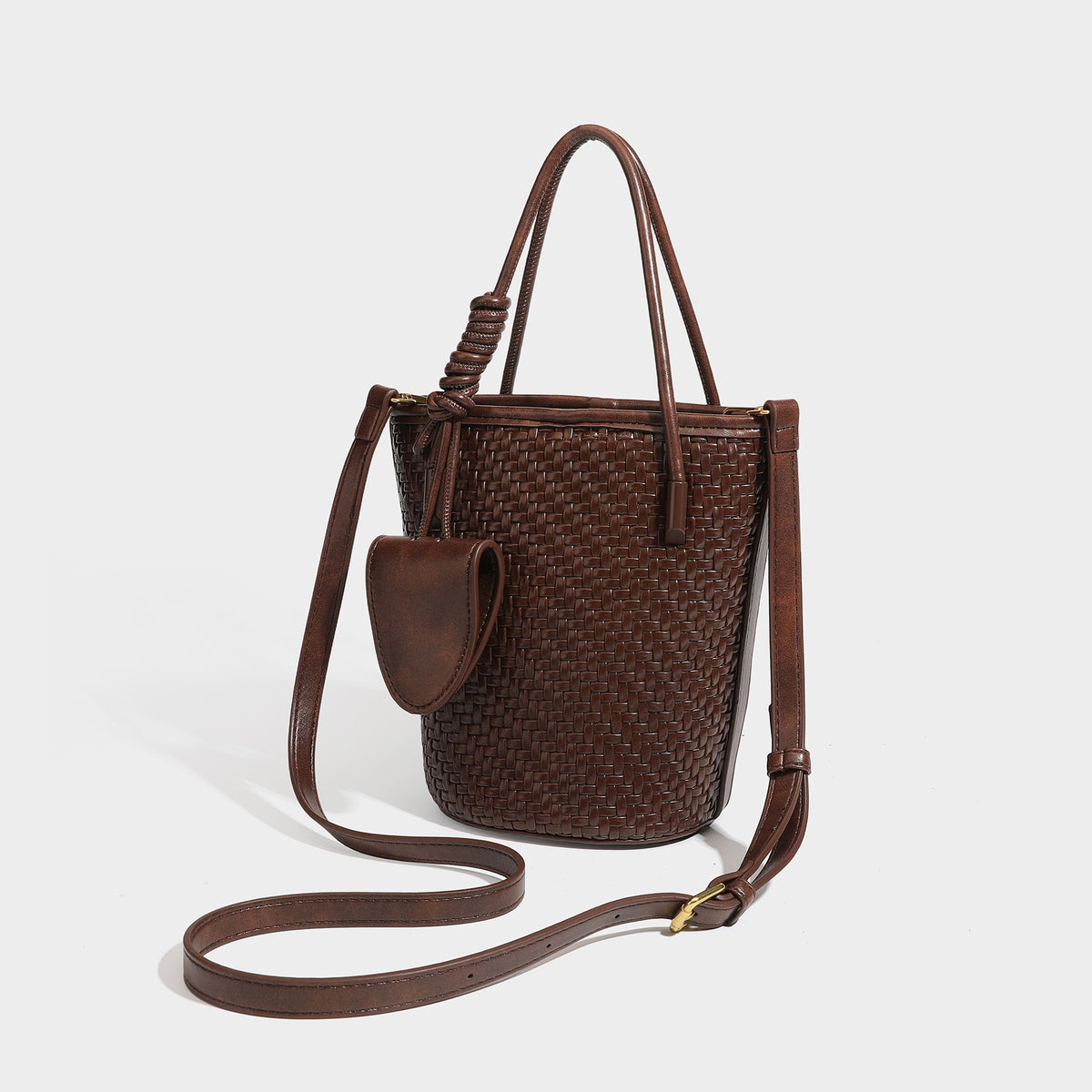 Structured woven-texture leather-look bucket bag in brown with knotted top handles, small front flap pouch, and adjustable