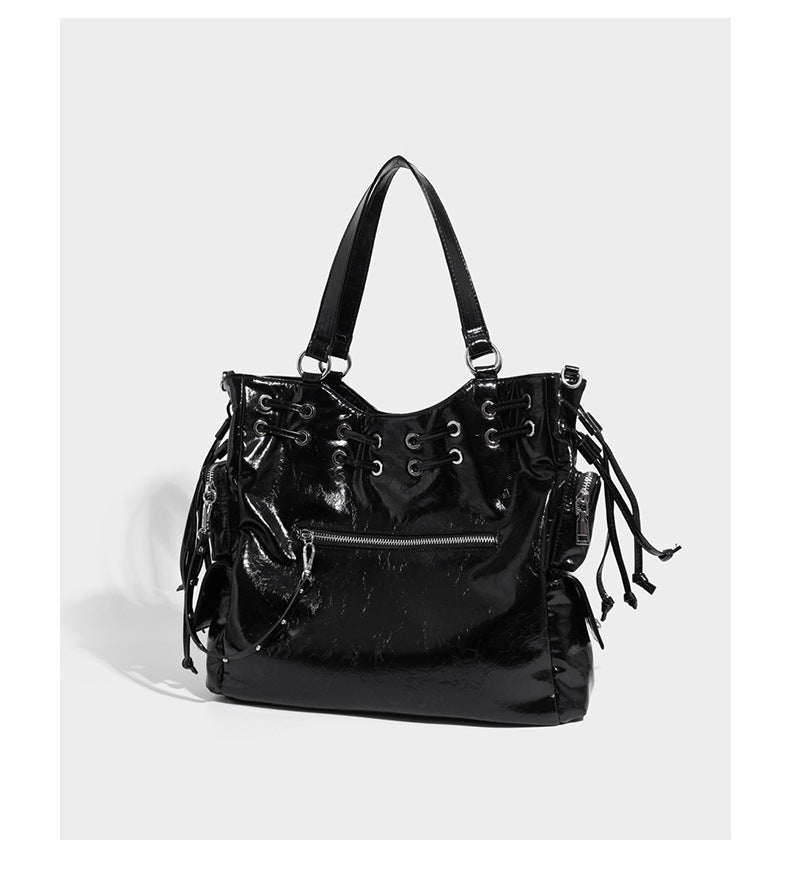 Glossy crinkled leather-look tote bag with silver grommet lace-up front detail, dual top handles, and detachable shoulder