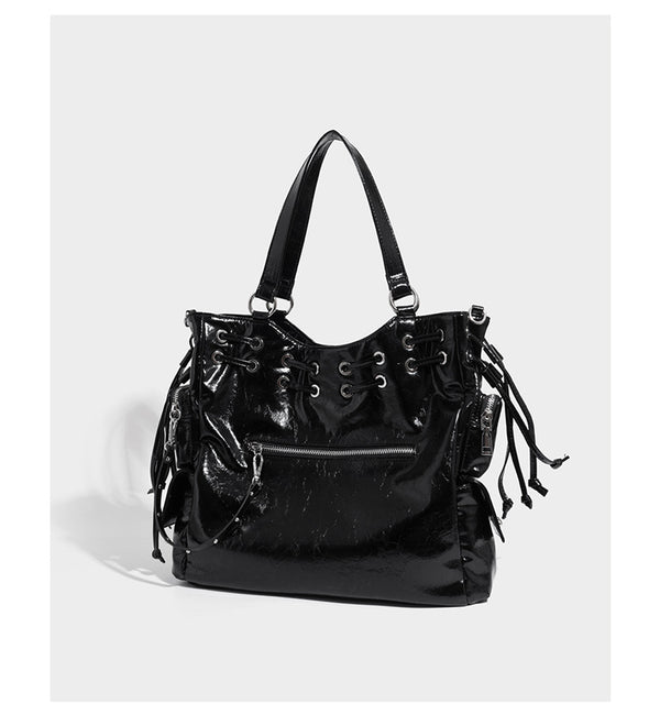 Glossy crinkled leather-look tote bag with silver grommet lace-up front detail, dual top handles, and detachable shoulder