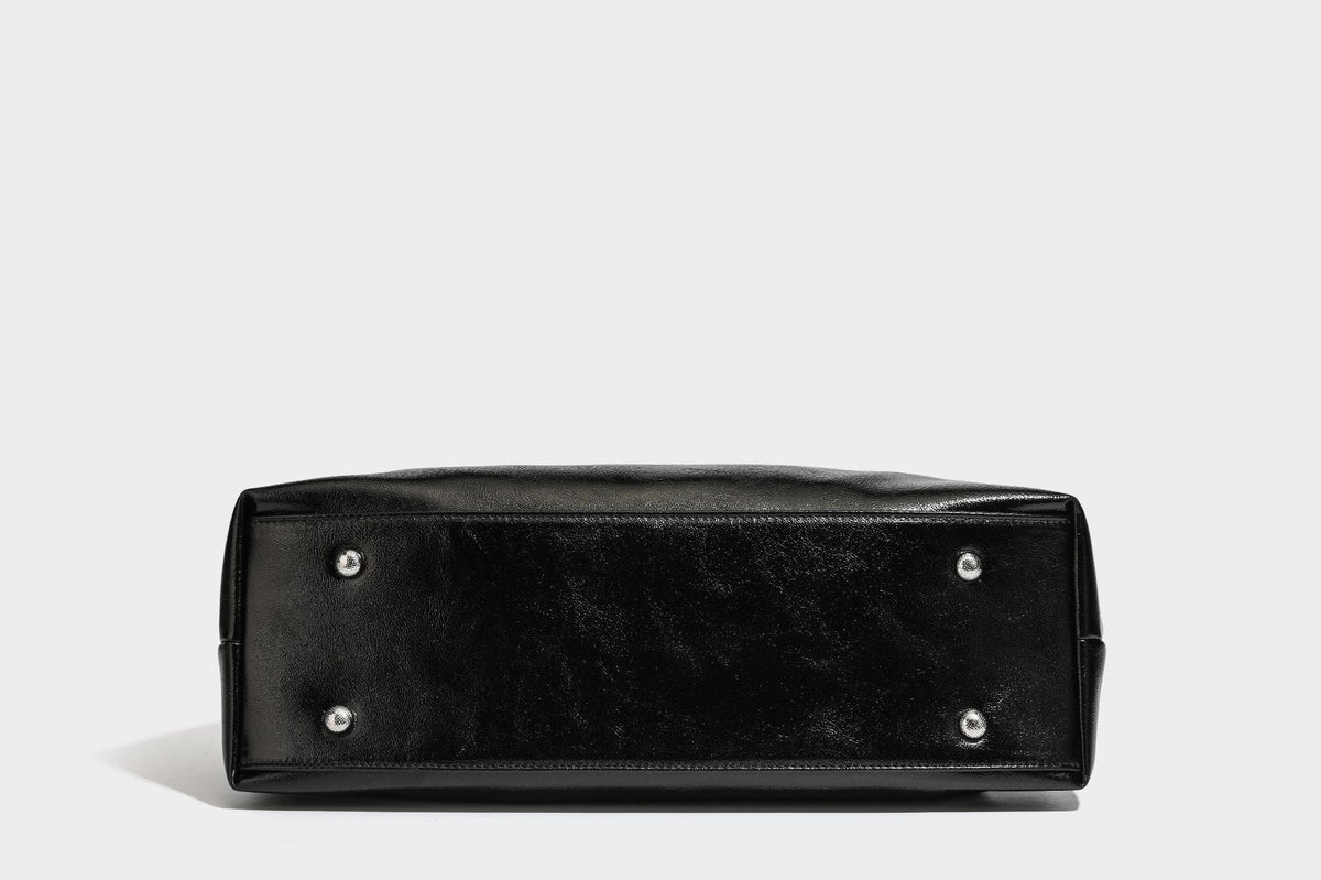 Glänzende schwarze, weich fallende Schultertasche mit gerafftem Abschluss, zwei langen Trageriemen, silberfarbenen Beschlägen und abnehmbarem Umhängeriemen