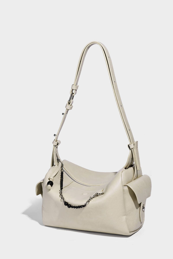 Small slouchy moto-style crossbody bag in smooth matte leather-look finish with white contrast stitching, silver-tone, detail
