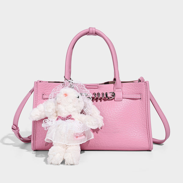 Structured trapezoid tote bag in pebbled leather-look finish with double top handles, silver-tone bar hardware, and, detail