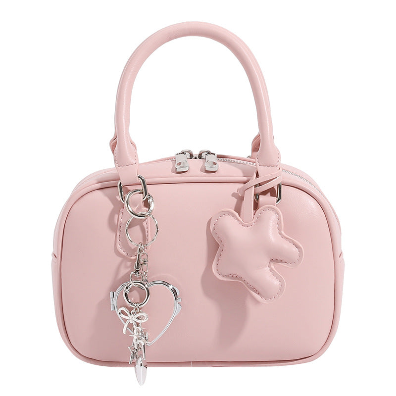 Small structured rounded-rectangle mini handbag with glossy leather-look finish, top zip closure, silver-tone hardware, and